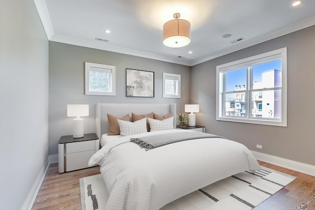 bedroom featuring baseboards, ornamental molding, and visible vents