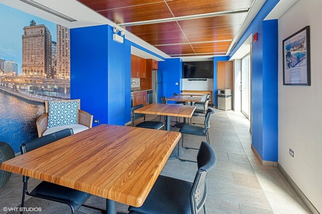 dining space featuring a city view, wood ceiling, and baseboards
