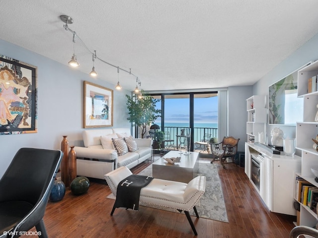 3660 N Lake Shore Dr Unit 3905, Chicago, IL 60613 - living area with dark wood-type flooring, expansive windows, a textured ceiling, a glass covered fireplace, and a water view