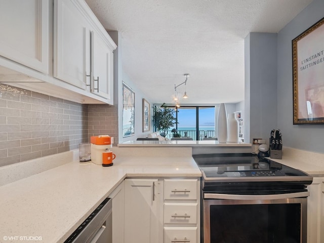 3660 N Lake Shore Dr Unit 3905, Chicago, IL 60613 - kitchen featuring stainless steel range with electric cooktop, rail lighting, decorative backsplash, light countertops, and white cabinetry