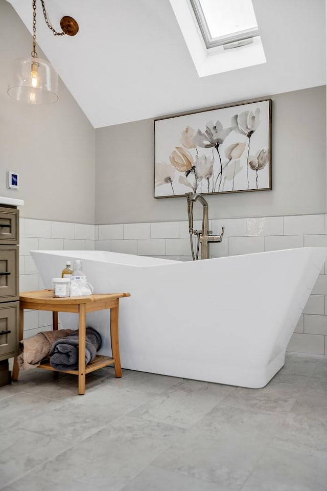 127 60th St, Downers Grove, IL 60516 - bathroom featuring tile walls, a skylight, vaulted ceiling, a soaking tub, and wainscoting