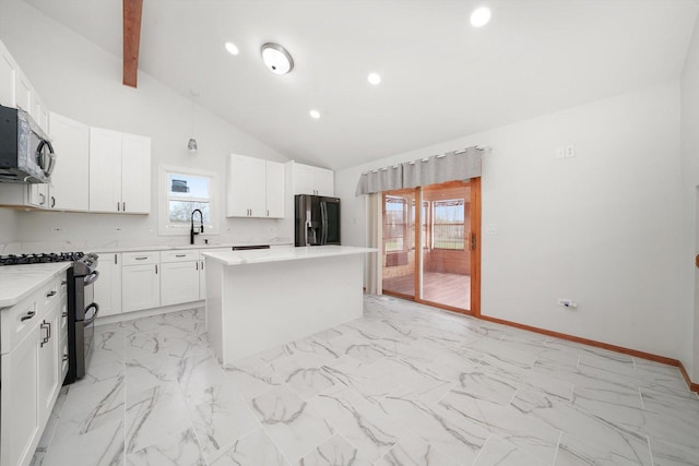kitchen with a sink, black refrigerator with ice dispenser, a center island, range with two ovens, and stainless steel microwave