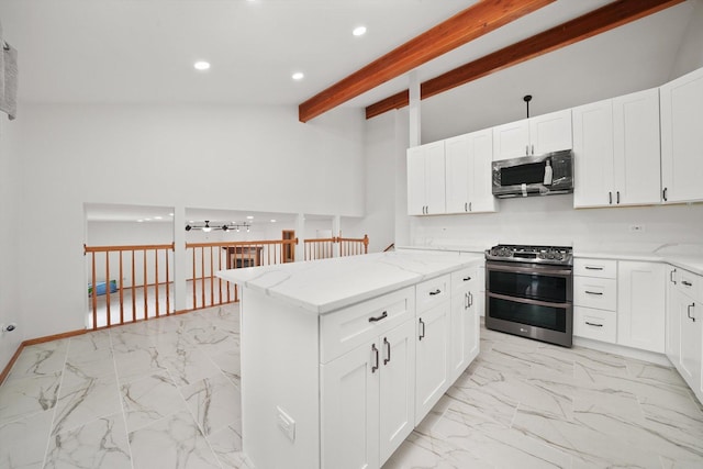 kitchen with beamed ceiling, appliances with stainless steel finishes, light stone counters, and marble finish floor