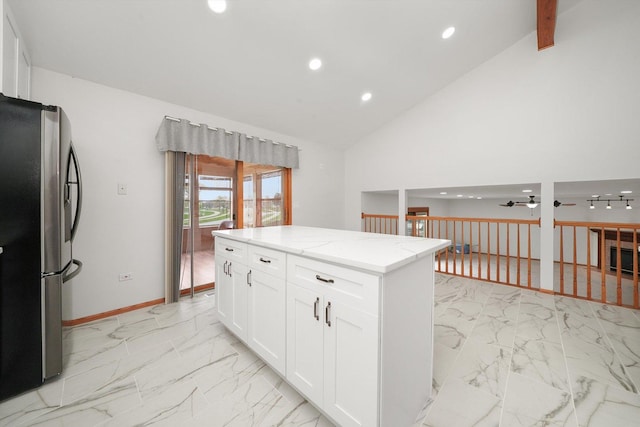 kitchen with light stone countertops, white cabinets, freestanding refrigerator, marble finish floor, and recessed lighting