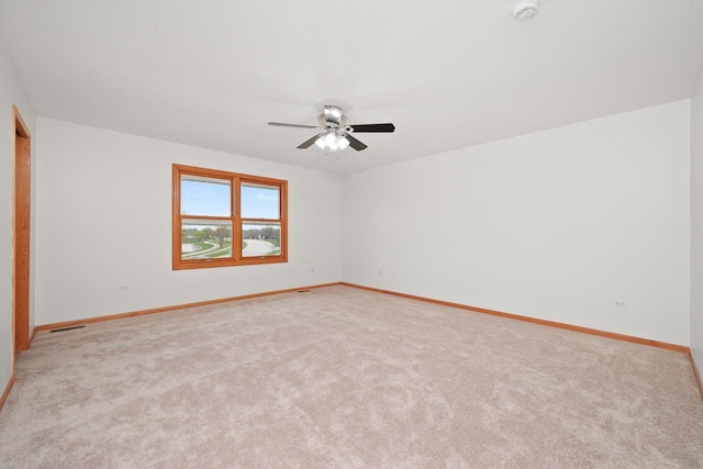 unfurnished room with baseboards, visible vents, light carpet, and ceiling fan