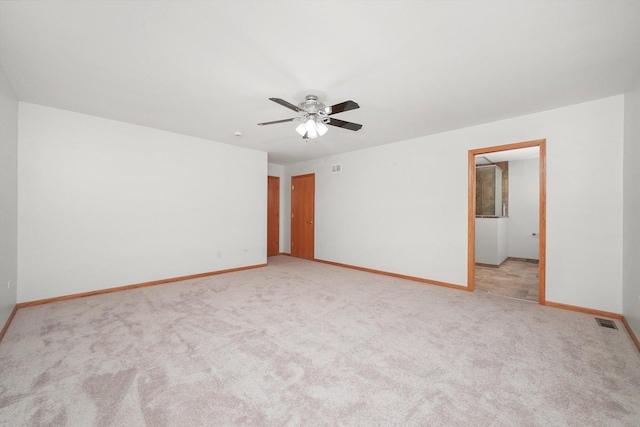unfurnished room featuring baseboards, ceiling fan, visible vents, and light carpet