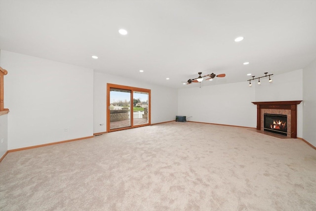 unfurnished living room featuring recessed lighting, baseboards, light colored carpet, and a fireplace