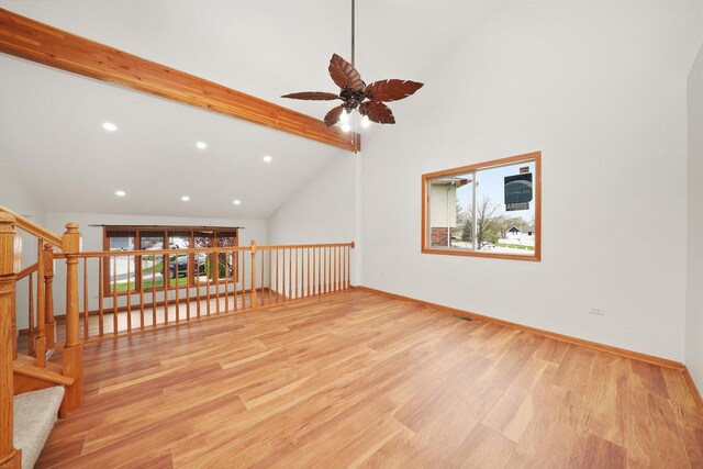 interior space with ceiling fan, lofted ceiling with beams, plenty of natural light, and wood finished floors