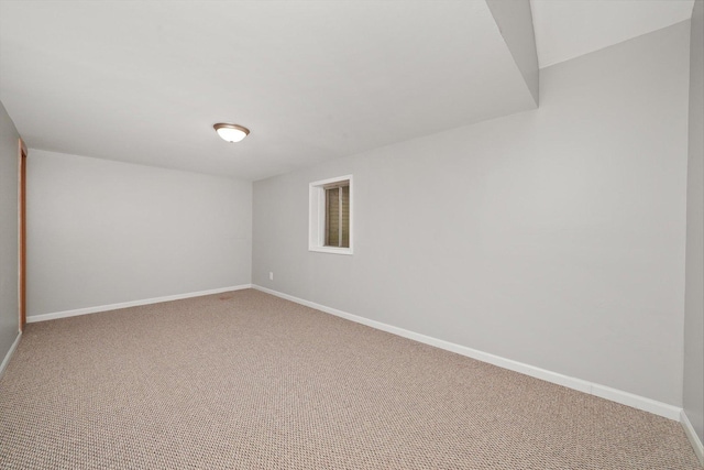carpeted spare room with baseboards