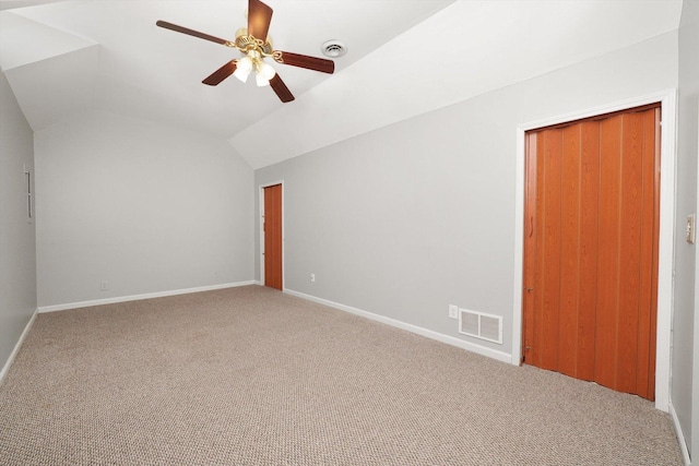 spare room with visible vents, carpet, ceiling fan, and vaulted ceiling