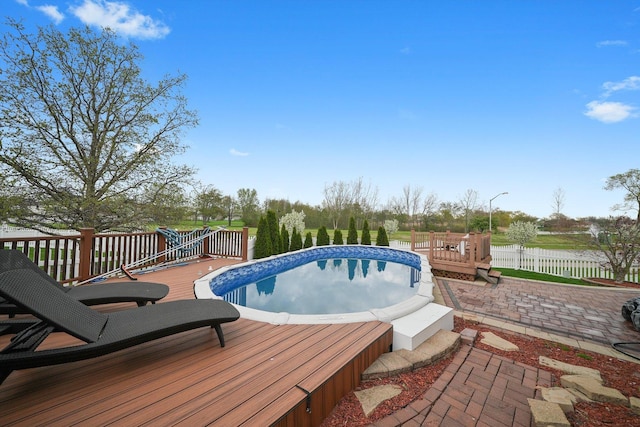 outdoor pool with fence and a deck