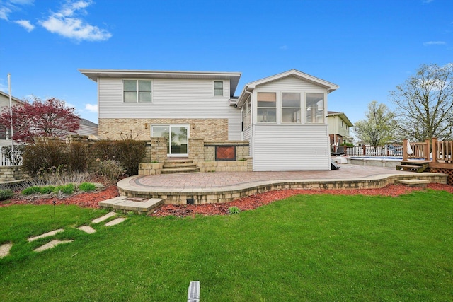 back of house with a lawn, a patio, and a sunroom
