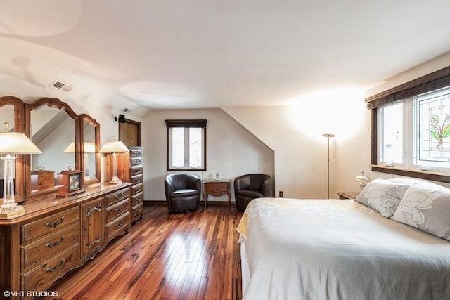 bedroom featuring visible vents, hardwood / wood-style flooring, and vaulted ceiling