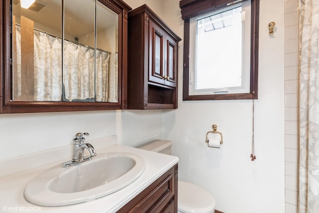 full bath featuring visible vents, toilet, curtained shower, and vanity