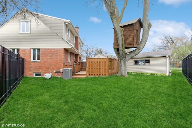 back of property featuring a chimney, central AC unit, a yard, and brick siding