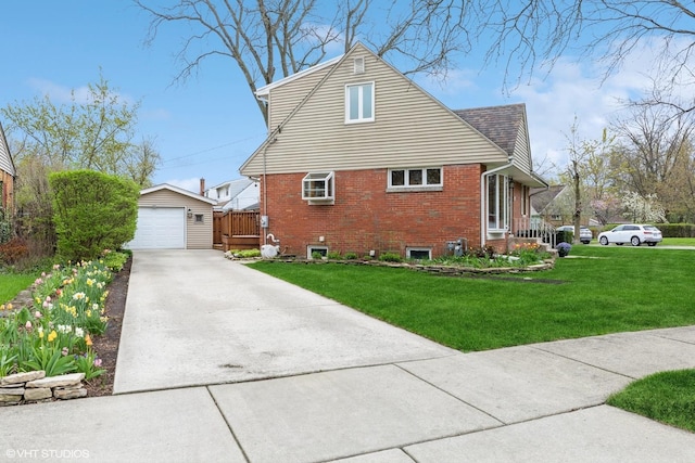 view of side of property with driveway, an outbuilding, a yard, brick siding, and a garage