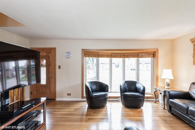 living area featuring light wood finished floors and baseboards