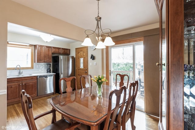 dining area with light wood-style floors and a chandelier