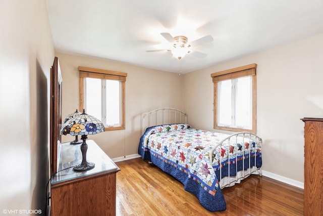 bedroom featuring baseboards, multiple windows, and light wood-style flooring