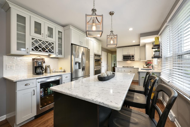 317 Roberts Rd, Inverness, IL 60010 - kitchen with light stone counters, a center island, stainless steel appliances, a kitchen bar, and wine cooler