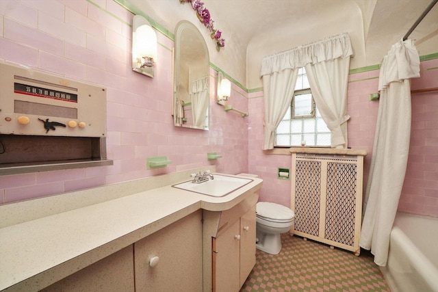bathroom featuring vanity, shower / bath combo with shower curtain, toilet, tile walls, and radiator heating unit