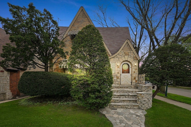 view of front of house with a front yard and stone siding