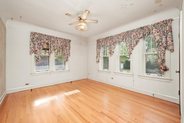 empty room featuring baseboards, ceiling fan, and wood finished floors