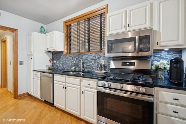 5840 N Saint Louis Ave Unit 2N, Chicago, IL 60659 - kitchen featuring stainless steel appliances, a sink, tasteful backsplash, light wood-style floors, and white cabinetry