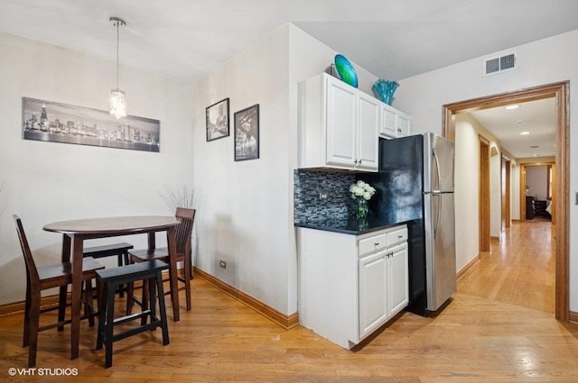 5840 N Saint Louis Ave Unit 2N, Chicago, IL 60659 - kitchen with light wood finished floors, dark countertops, visible vents, freestanding refrigerator, and white cabinetry