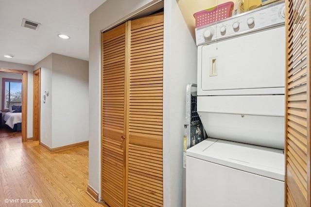 5840 N Saint Louis Ave Unit 2N, Chicago, IL 60659 - clothes washing area with visible vents, baseboards, light wood-style floors, stacked washer and clothes dryer, and laundry area