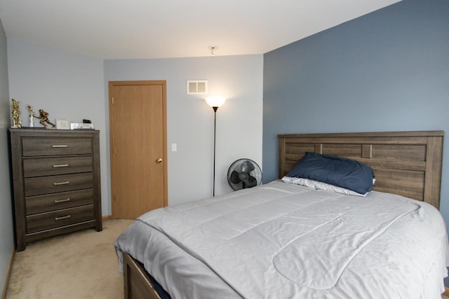 bedroom with visible vents and light carpet