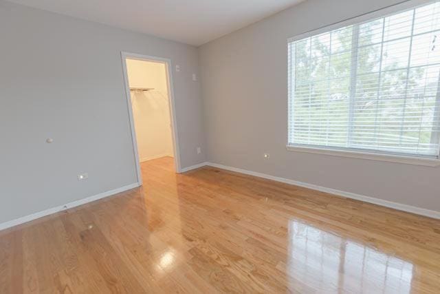 spare room featuring baseboards and light wood-type flooring