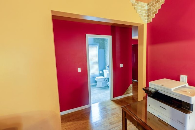 hallway featuring wood finished floors and baseboards