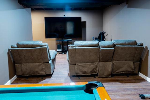cinema room featuring wood finished floors and baseboards