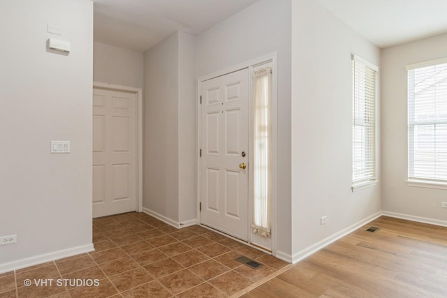 foyer with wood finished floors, visible vents, and a healthy amount of sunlight