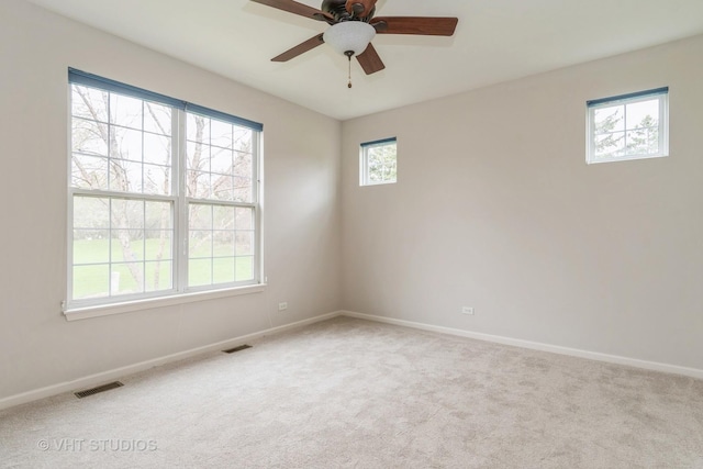 carpeted empty room featuring ceiling fan, baseboards, and visible vents