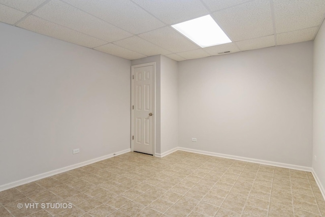spare room featuring baseboards, visible vents, and a paneled ceiling