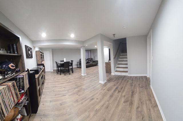 interior space featuring light wood-type flooring, baseboards, recessed lighting, and stairs