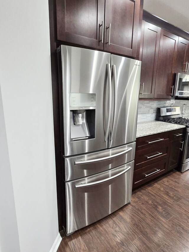 kitchen featuring dark brown cabinetry, stainless steel appliances, dark wood-style flooring, and decorative backsplash