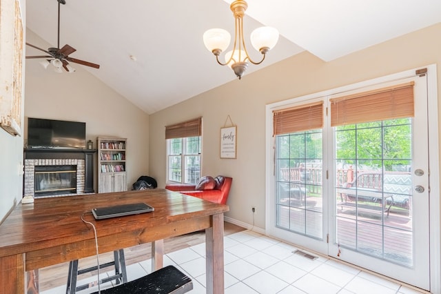 dining space with visible vents, vaulted ceiling, a brick fireplace, light tile patterned floors, and ceiling fan with notable chandelier