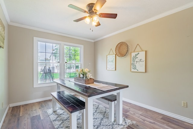 dining space featuring baseboards, crown molding, and wood finished floors
