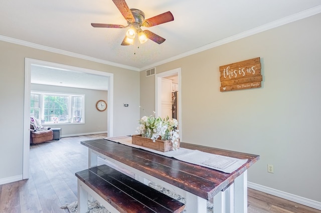 dining area with baseboards, visible vents, ornamental molding, and light wood-type flooring