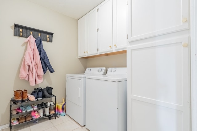 laundry area with light tile patterned floors, separate washer and dryer, and cabinet space