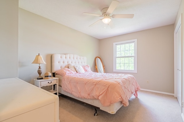 bedroom with a ceiling fan, baseboards, and light carpet