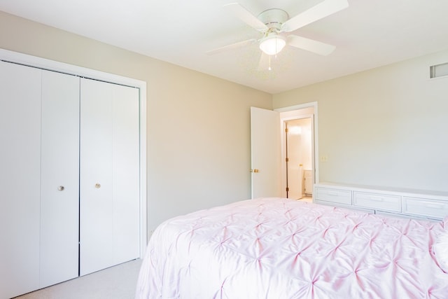 bedroom with ceiling fan, light colored carpet, and a closet