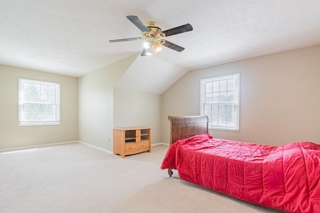bedroom featuring baseboards, carpet flooring, vaulted ceiling, and multiple windows