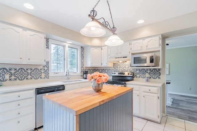 kitchen featuring a kitchen island, white cabinetry, under cabinet range hood, appliances with stainless steel finishes, and light tile patterned floors