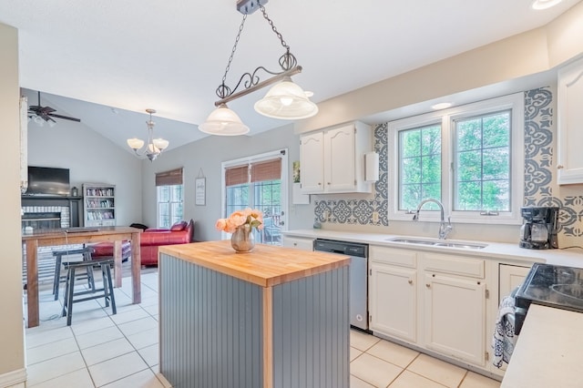 kitchen with butcher block countertops, dishwasher, a sink, light tile patterned floors, and white cabinetry