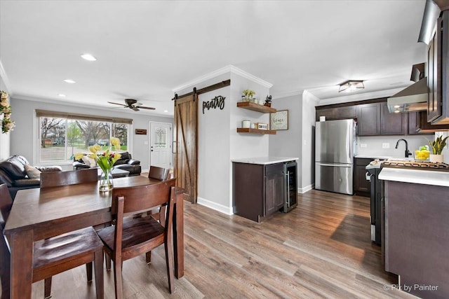 219 E Streamwood Blvd, Streamwood, IL 60107 - dining space featuring crown molding, a barn door, beverage cooler, recessed lighting, and wood finished floors