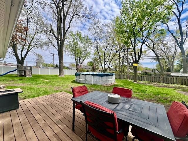 219 E Streamwood Blvd, Streamwood, IL 60107 - wooden terrace featuring a fenced in pool, outdoor dining area, a lawn, and a fenced backyard